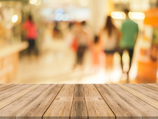 Wooden board empty table in front of people shopping at market fair background. Perspective wood and blur market - can be used for display or montage your products - vintage effect style pictures.
