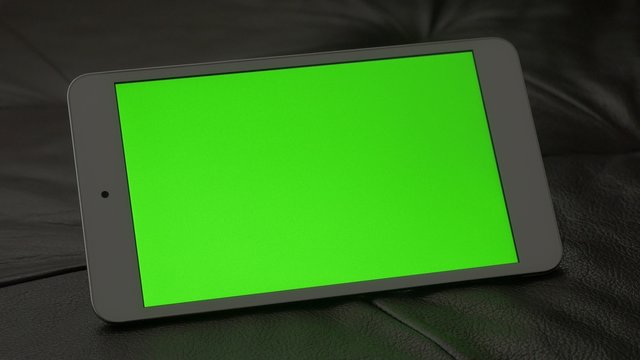 Green screen presented on  PC tablet computer 4K 2160p UltraHD footage - PC silver tablet on leather sofa 4K 3840X2160 UHD video