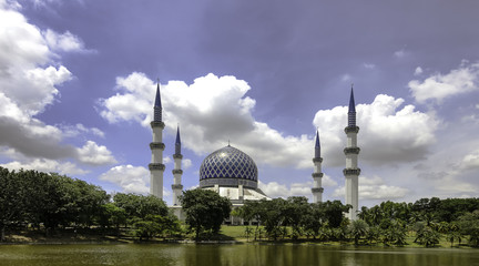The beautiful Sultan Salahuddin Abdul Aziz Shah Mosque (also known as the Blue Mosque) located at Shah Alam, Selangor, Malaysia during daytime with clouds scattered.