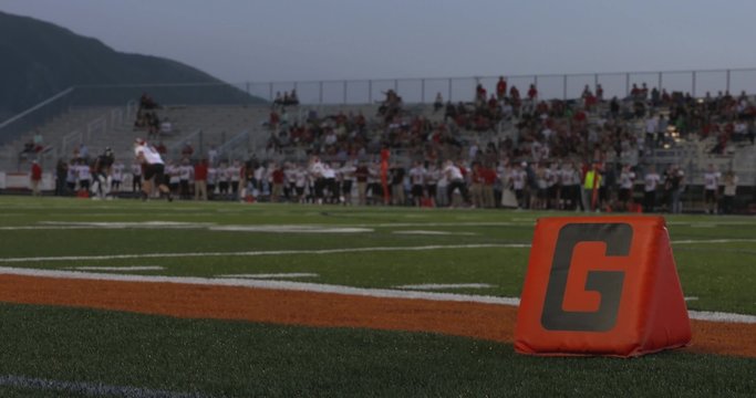 A shot of the goal line as high school football players play in the distance.