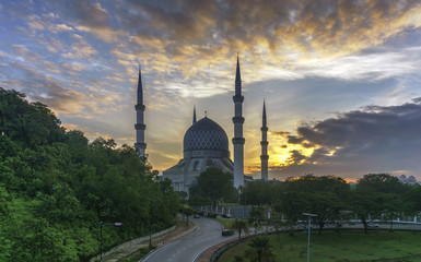 Fototapeta na wymiar The beautiful Sultan Salahuddin Abdul Aziz Shah Mosque (also known as the Blue Mosque) located at Shah Alam, Selangor, Malaysia during sunrise.