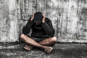overdose asian male drug addict with problems, man in hood with hands on his head