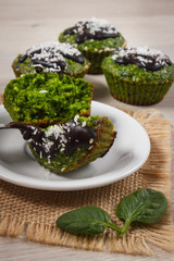 Fresh muffins with spinach, desiccated coconut and chocolate glaze, delicious healthy dessert