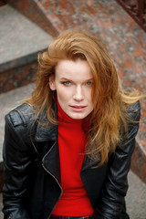 Fototapeta na wymiar portrait of red hair lady in leather jacket with cardboard cup i