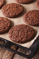 Freshly baked chocolate cookies on a baking sheet close-up. vertical