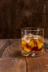 Faceted glass of whiskey with ice