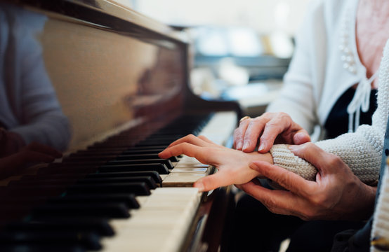 experienced hand of  old music teacher helps  child  pupil
