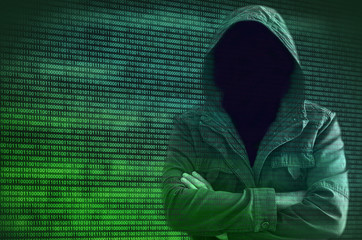 Hacker without face surrounded by binary code