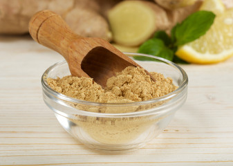 ginger root and powder on wooden background