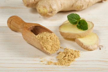 ginger root and powder on wooden background