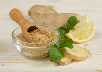 ginger root and powder on wooden background