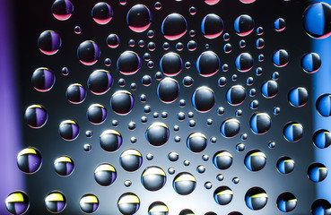 multicolored drops of water on black background