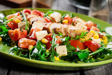 Fresh salad with chicken breast, arugula and tomato