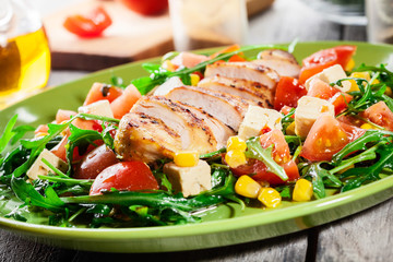 Fresh salad with chicken breast, arugula and tomato