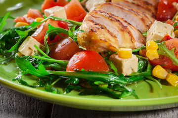 Fresh salad with chicken breast, arugula and tomato