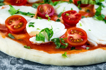 Prepering margherita pizza with mozzarella for baking