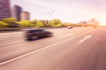 Fototapeta na wymiar Car driving on road at sunset, motion blur