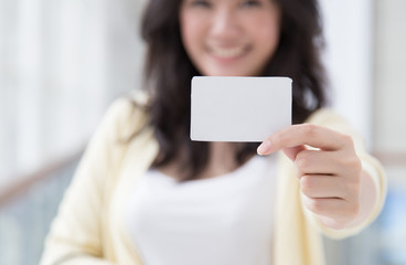 Asian woman holding a card in her hand
