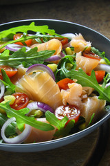 Salad with arugula, tomatoes, corn, smoked salmon and red onion