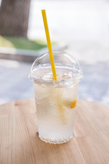 Lemonade,  a refreshing drink in a plastic cup.  Street backgrou