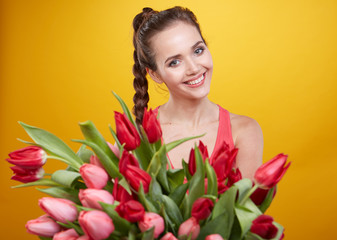 Obraz na płótnie Canvas Young beautiful woman studio portrait with tulip flowers