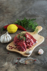 Raw lamb meat with spices on wood board over old wooden backgrou
