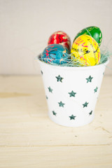 Handmade Easter eggs in white candlestick on a wooden table