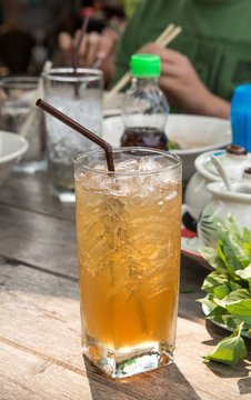 Glass tamarind juice with ice on wooden table