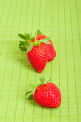 Strawberries, close-up on green background