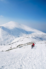 Naklejka na ściany i meble Tourist hike in a winter mountains