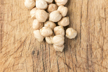 Uncooked chickpeas over wooden table close up.