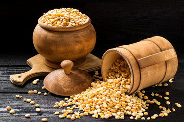 Dry yellow peas in a wooden pot and mug