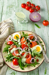 Smoked salmon salad with arugula, tomatoes, eggs and red onion