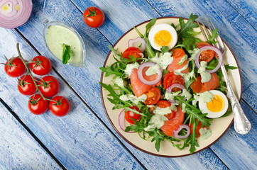 Smoked salmon salad with arugula, tomatoes, eggs and red onion