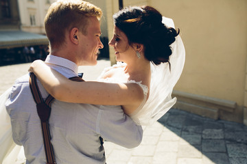 groom carries bride in his arms