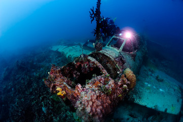 Scuba diver exploring wreck plane in the deep.