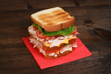 chicken club sandwich on red napkin