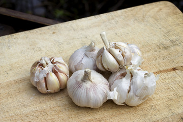 sliced garlic, garlic clove, garlic bulb on chopping block