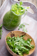 Rucola smoothie, on the grey  background.