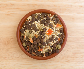 Quinoa and lentil dry soup mix in a small bowl atop a wood table top.