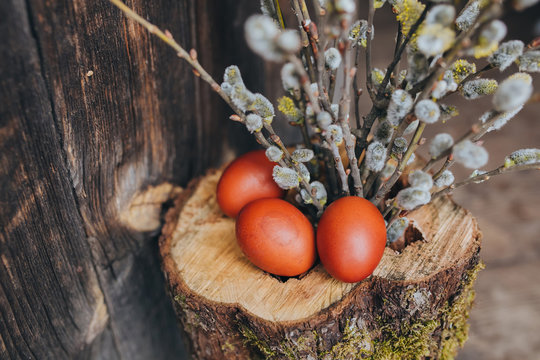 Easter eggs on a wooden background with branch of willow
