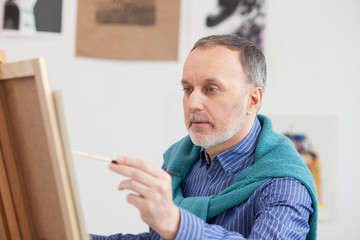 Naklejka na ściany i meble Senior male painter is creating new picture