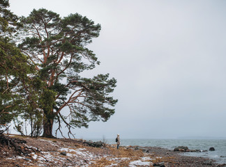 A woman on the old beach starring at the restless Sea