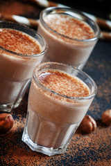 Banana chocolate smoothie with nuts, dusted with a powder, healt