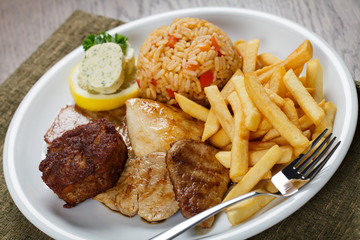 Grillteller mit Pommes frites und Paprikareis