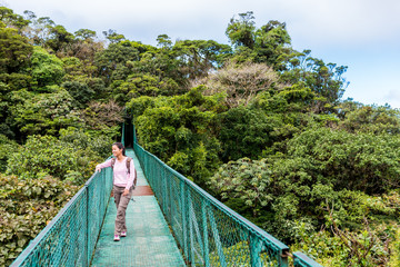 Naklejka premium Girl on hanging bridge in cloudforest - Monteverde, Costa Rica