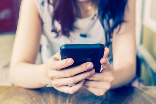 Hand Woman Using Phone In Coffee Shop With Depth Of Field.