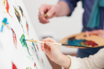Naklejka premium Cheerful mature painter and his small pupil