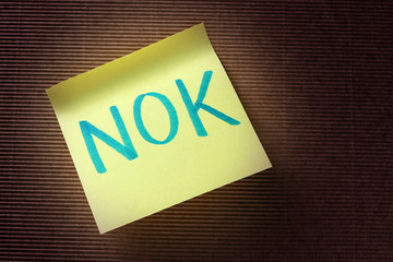 NOK (Norwegian Krone) acronym on yellow sticky note