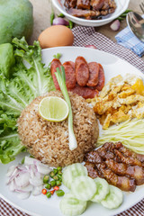 Rice maxed with shrimp paste is Thai Food ingredients are rice, shrimp paste, shallots, chili, fried egg, sweet pork, cucumber, sausage and mango.